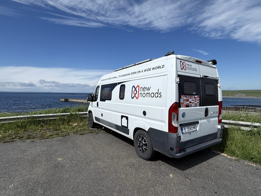 The New Nomads campervan parked by the sea near the old ferry port on Orkney's Mainland