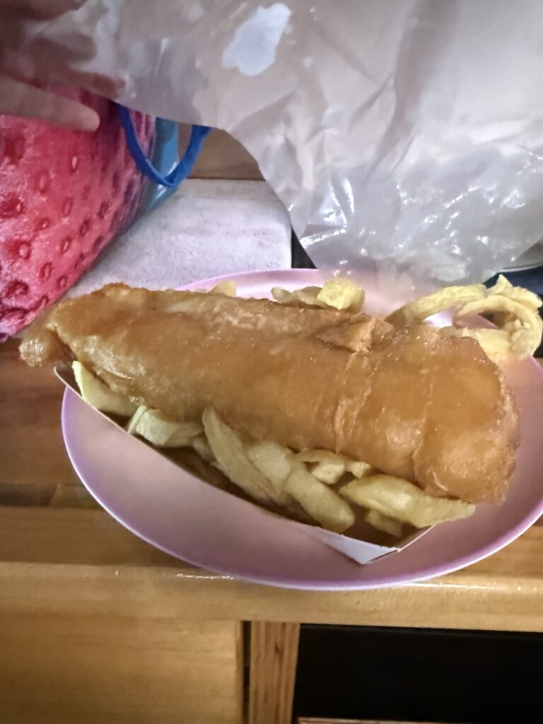 Fish and chips wrapped in paper, shared on the common