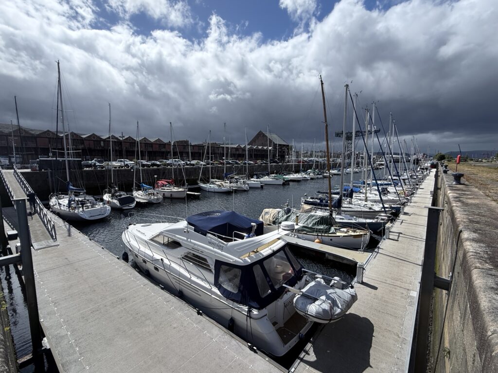 The New Nomads campervan parked right beside the water at James Watt Dock Marina in Greenock