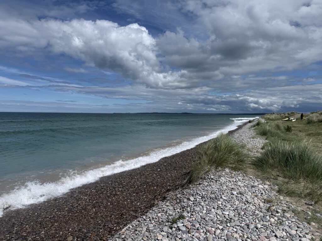 The wide, open sands of Findhorn Beach stretching along the North Sea