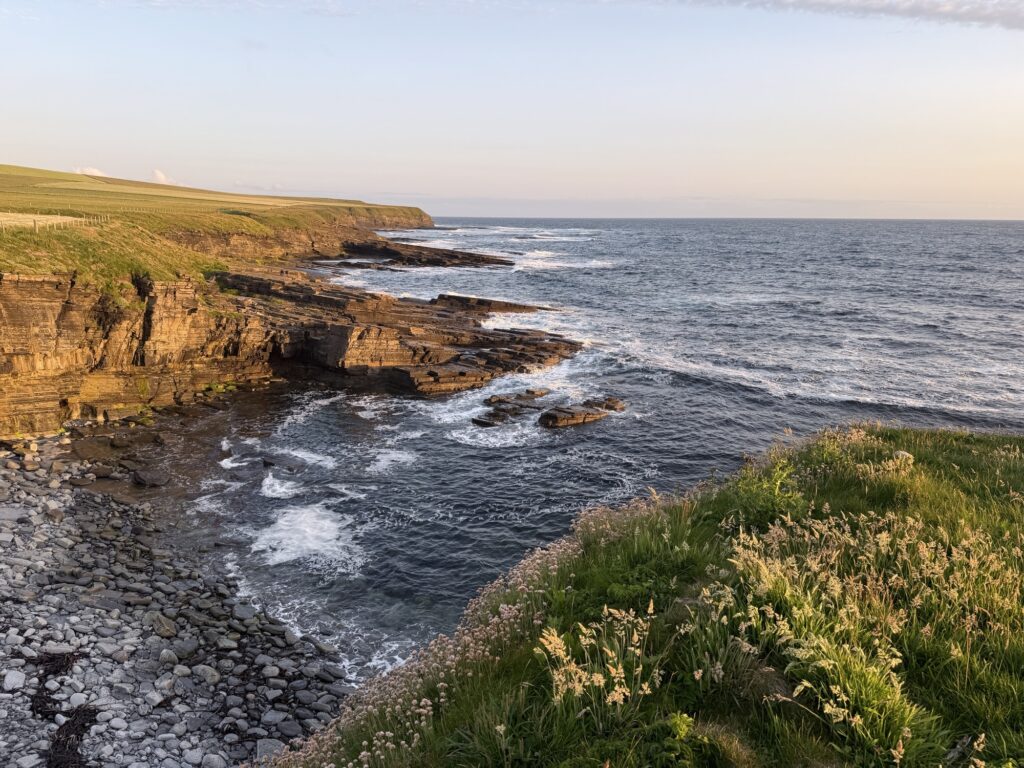 An empty pale-sand beach on Orkney under a wide northern sky