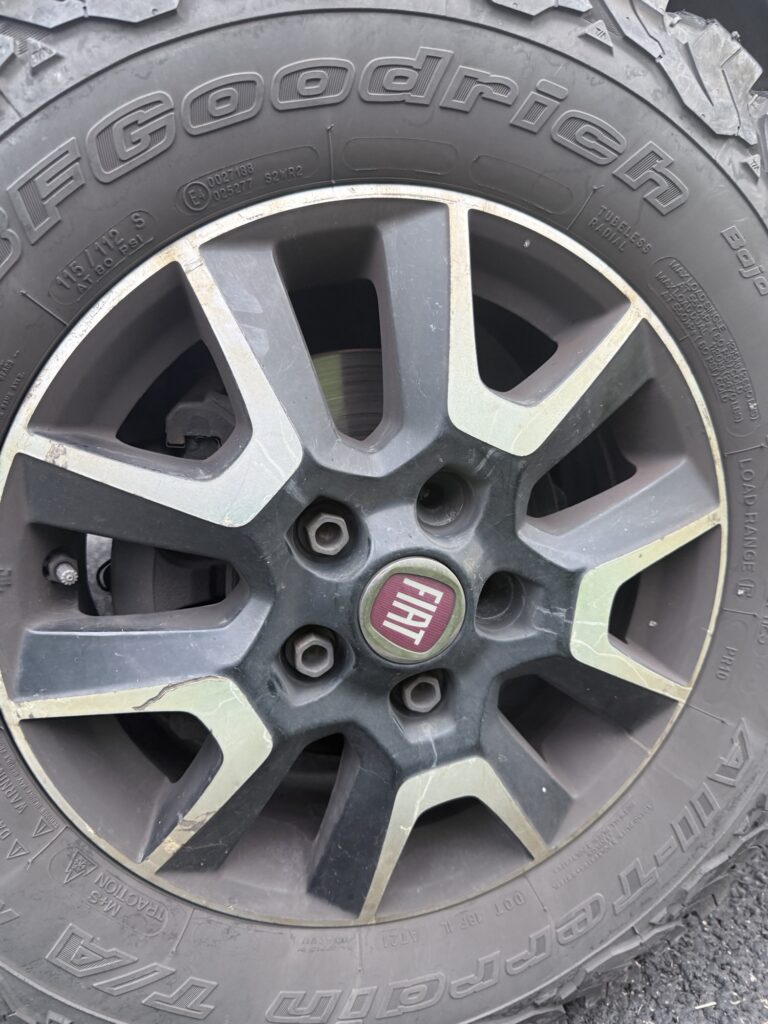 A campervan wheel with two lug nuts missing from the hub