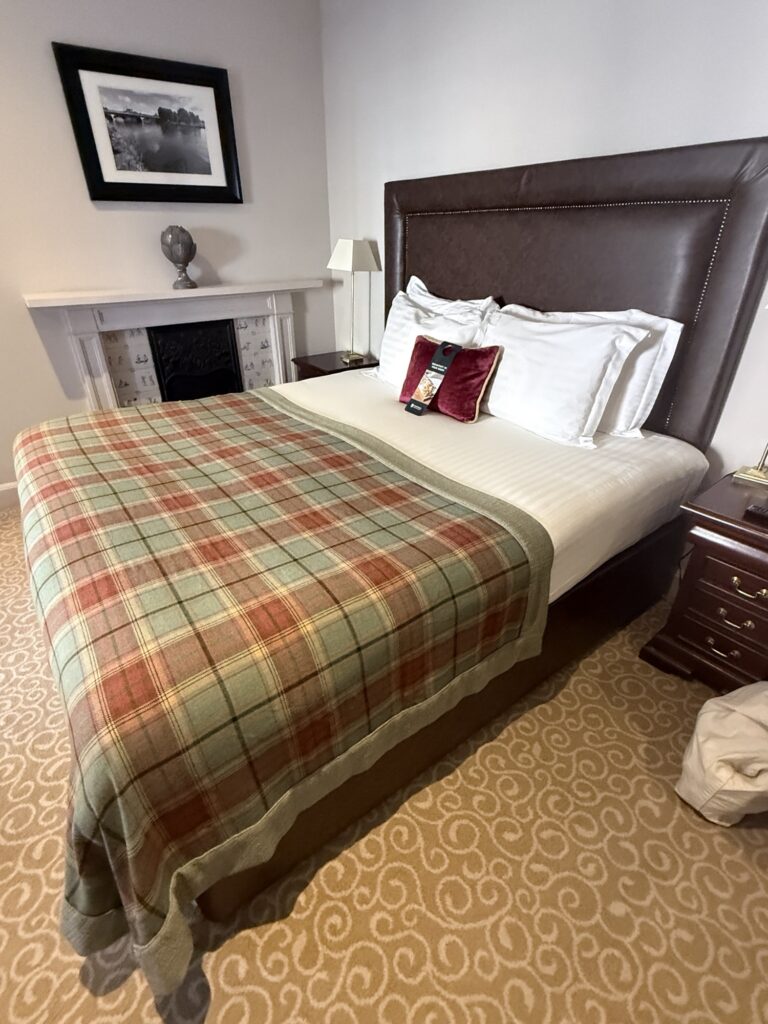 A grand, warmly furnished bedroom at Pittodrie House