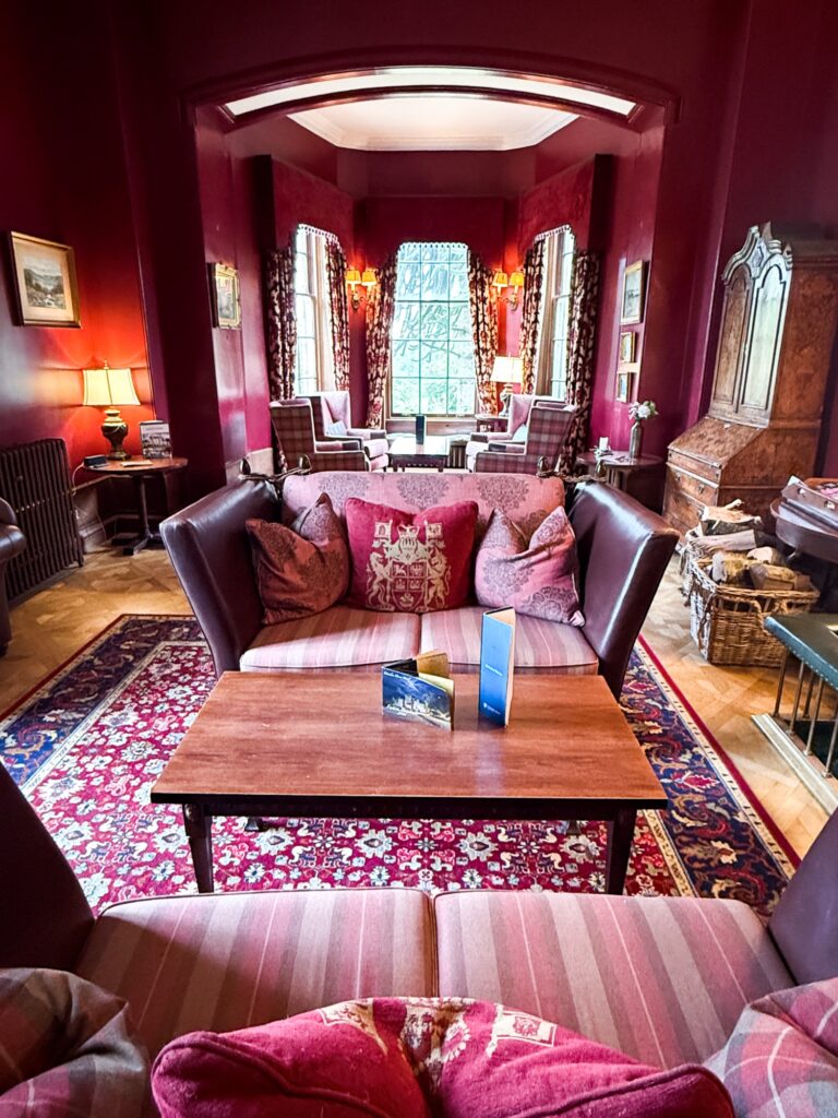 A grand country-house lounge with a fire at Pittodrie House